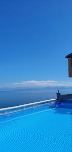 a swimming pool with the ocean in the background at Olga's Apartments in Ágios Dimítrios