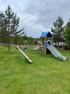 a group of playground equipment in a grass field at Halvorseth in Prestfoss