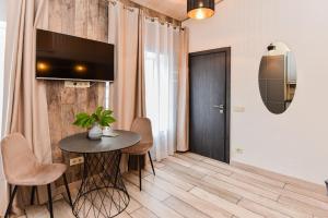 a living room with a table and a television on a wall at Bastiono apartamentai in Klaipėda