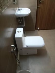 uma casa de banho com um lavatório branco e um WC. em ECR River Valley em Kodūr