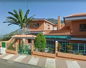a building with a palm tree in front of it at La Casita de mi Alma - Das Haus meiner Seele (Tegueste) in Tegueste