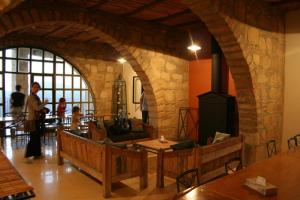 a living room with a fireplace and a stone wall at Dana Guesthouse in Dana