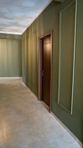 een lege kamer met groene muren en een deur bij Babilon Hotel Tbilisi in Tbilisi City