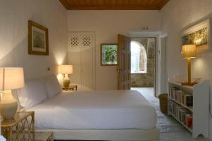 ein Schlafzimmer mit einem großen weißen Bett und zwei Lampen in der Unterkunft Patrick & Joan Leigh Fermor House in Kardhamili