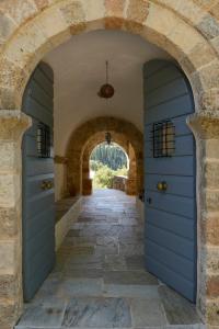 an archway in a building with a blue door at Patrick & Joan Leigh Fermor House in Kardamyli