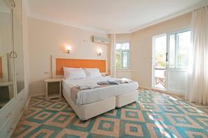 a bedroom with a large bed and a large window at Chillos Beach in Marmaris