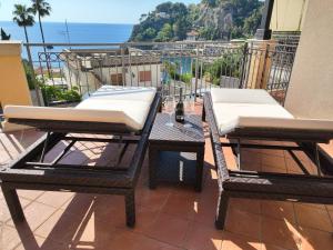 two beds on a balcony with a view of the ocean at DHOME Baia Mazzaro' in Taormina