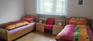 a bedroom with two beds and a chair and a window at Ferienwohnung Klötsch in Katzwinkel