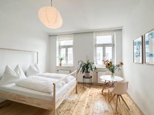 a white bedroom with a bed and a table at Central Apartment next to Belvedere Castle in Vienna