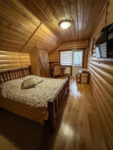 sypialnia z łóżkiem w drewnianym domku w obiekcie GorodOk w mieście Migowo