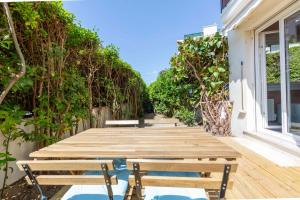 カンヌにあるSecret Garden ideal for Congrès and Holidays LIVE IN LE FLORENCEのデッキにベンチが置かれた木製の通路