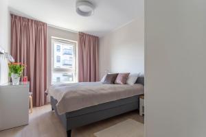 a bedroom with a bed and a window at Betty by Q4Apartments in Gdańsk