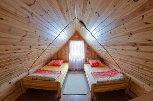 a room with two beds in a wooden cabin at Agroturystyka Nad Tanwią in Biszcza