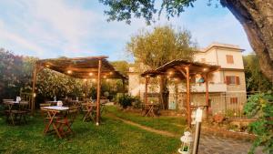um pátio com mesas e guarda-sóis num quintal em Villa Rosa Cilento em Caprioli