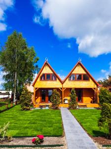 韋巴的住宿－Domki drewniane całoroczne Zielona Łeba，一座带绿色草坪的大型木屋