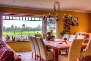 a dining room with a table and chairs and a large window at Vakantiehuis Aen de Roderburgh in Maaseik