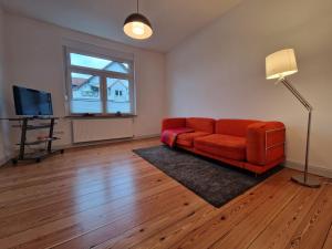 ein Wohnzimmer mit einem roten Sofa und einem TV in der Unterkunft Stylisches Apartment in Hohenlimburg in Hagen