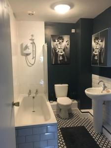 a bathroom with a tub and a toilet and a sink at Flat 8 Buxton Town centre apartment in Buxton