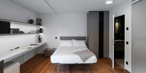 a white bedroom with a bed and a desk at Lo Scudo di Stabio in Stabio