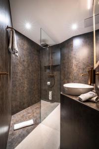 a bathroom with a sink and a glass shower at Boutique Hotel La Gorge in Saas-Fee