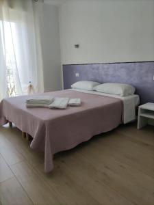 sypialnia z dużym łóżkiem z dwoma ręcznikami w obiekcie Appartamenti Bellini w mieście Bardolino