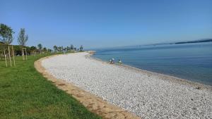 een strand met twee mensen erop naast het water bij Active Apartments Koper in Koper