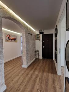 an empty hallway with a brick wall and an archway at Salt Lake Apartment in Techirghiol