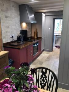 a kitchen with a table and a stove top oven at Hornes Cottage in Longborough