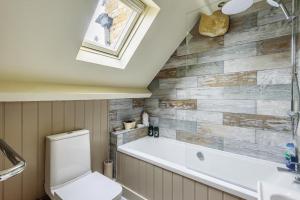 a bathroom with a toilet and a bath tub at Hornes Cottage in Longborough +3 photos