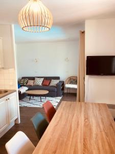 a living room with a table and a couch at Bel appartement cosy en résidence avec piscine in Deauville