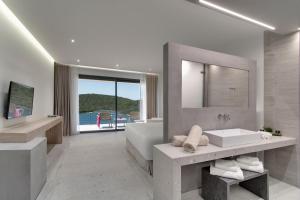 a bathroom with a tub and a sink and a mirror at Sivota Deamaris Luxury Boutique Hotel in Syvota