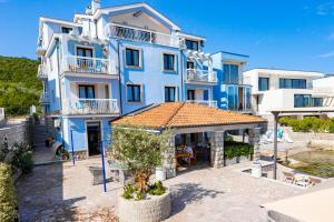 a large blue building with a table in front of it at Apart-hotel Villa Lav in Tivat