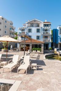 a group of chairs and umbrellas next to a building at Apart-hotel Villa Lav in Tivat