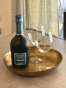 una botella de vino y dos copas de vino en una bandeja en Sweet Home 3 bedrooms free parking, en Lugano