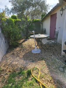 a backyard with a table and a hose at Chambre d'hôtes Esterelle in Pernes-les-Fontaines