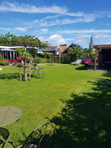 a lawn with a table and chairs in a yard at B&B WELKOM Zierikzee in Zierikzee