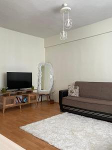 uma sala de estar com um sofá e uma televisão de ecrã plano em Welcome 1 em Istambul