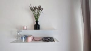 un estante blanco con un jarrón con platos y bebidas en Vila Luka, en Hvar
