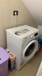 a white washing machine sitting in a room at Il Gelsomino House in Avola