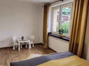 una camera da letto con un letto, una finestra e un tavolo di Apartament 20tka a Szczawnica Altre 2 foto