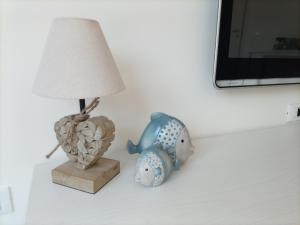 a lamp and a figurine of a fish on a table at Mirasole Holiday House in Leggiuno