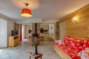 een woonkamer met een rode bank en een tafel bij Le Chasseforêt in Termignon