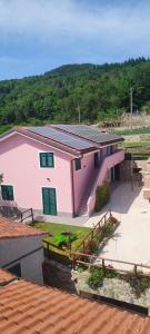 une maison rose avec des panneaux solaires en haut dans l'établissement Agriturismo Ca' du Nibile di Bove Gabriele, à Carbuta