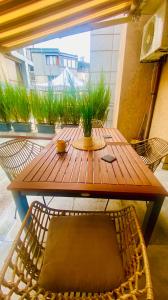 une table et des chaises en bois avec une plante. dans l'établissement Burgas apartment, à Bourgas