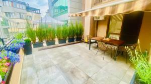 a patio with a table and chairs and potted plants at Burgas apartment in Burgas City