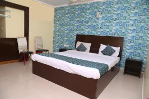 a bedroom with a bed and a blue wall at Hotel Destiny Delight in Visakhapatnam