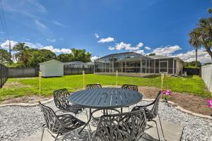 a table and chairs in front of a building at Charming N Fort Meyers Retreat Pool and Lanai! in North Fort Myers