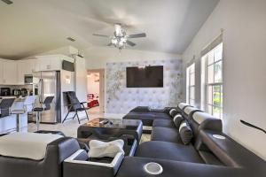 a living room with black leather furniture and a kitchen at Charming N Fort Meyers Retreat Pool and Lanai! in North Fort Myers