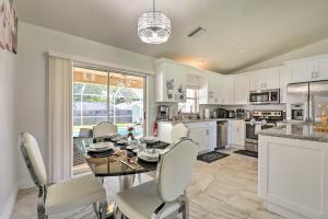 a kitchen with white cabinets and a table and chairs at Charming N Fort Meyers Retreat Pool and Lanai! in North Fort Myers