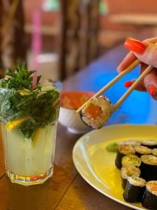 stół z talerzem sushi i drinkiem w obiekcie Золотий Дракон w mieście Haysyn